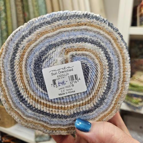Rolled-up fabric with a label held by a hand.