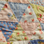 Close-up of a patchwork quilt with floral and geometric patterns.