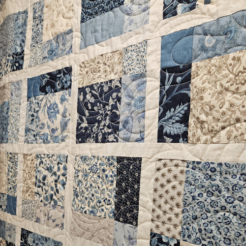 Quilt with patchwork pattern in blue and beige tones