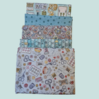 Set of four fabric swatches with sewing-themed patterns on a light blue background