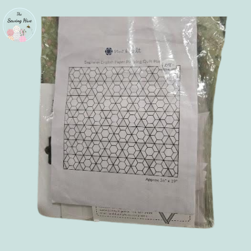 Quilt pattern paper with geometric design in a clear plastic sleeve on a light blue background.